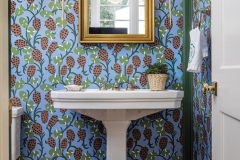 A whimsical Pierre Frey wallpaper enlivens the powder room.