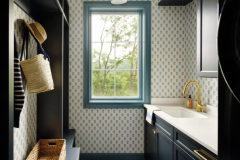 The laundry/mud room has cabinetry by Brookside Lumber, lighting by Hudson Valley and Thibaut wallcovering. The tile is by Emser Design. 